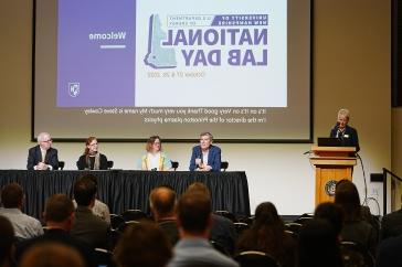 A panel of National Lab scientists talk under a slide that says "UNH DOE National Lab Day